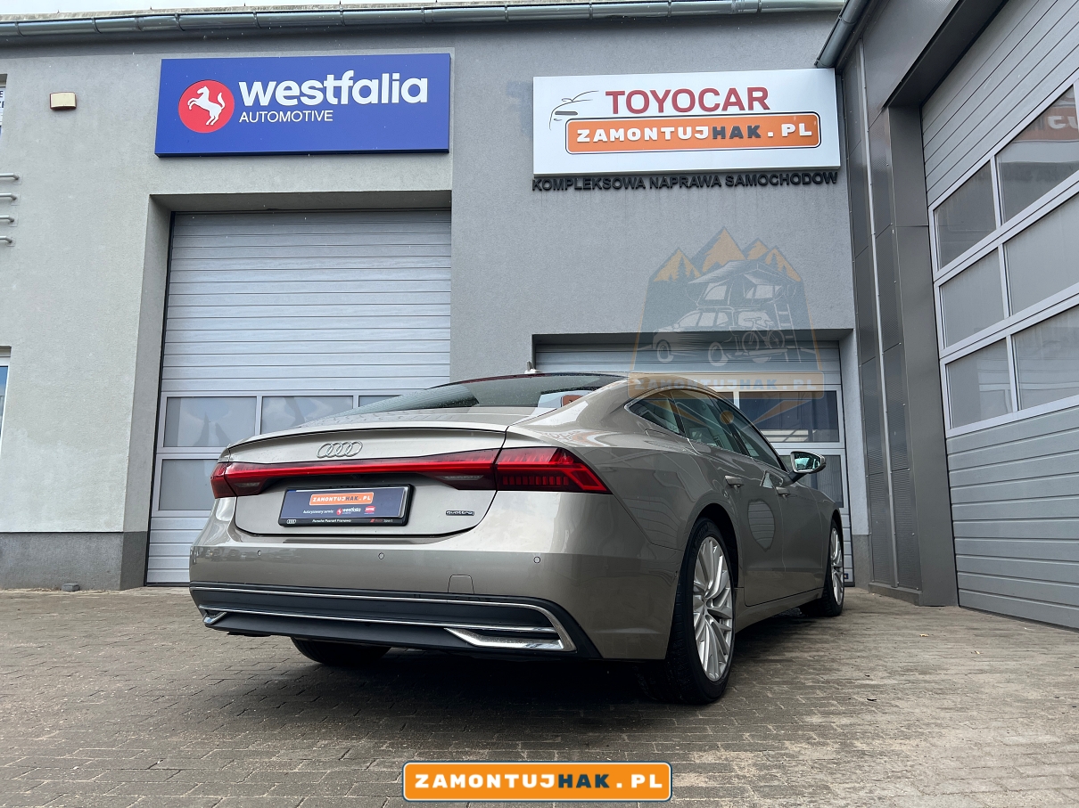 Elegancki hak holowniczy Westfalia A40V zamontowany w Audi A7 C8 2021, widoczny na tle warsztatu montażowego w Poznaniu.